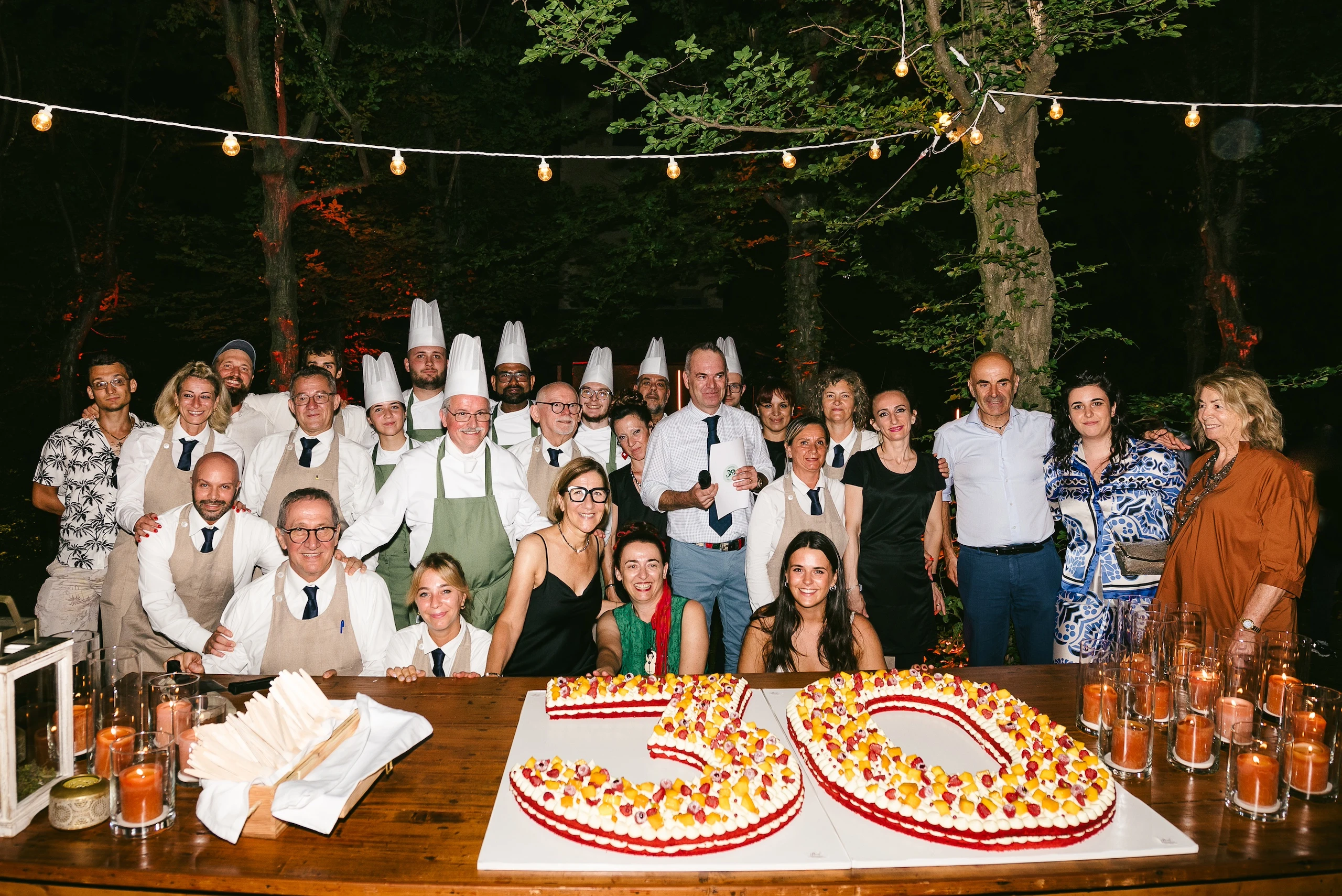 Foto di gruppo dello staff e degli ospiti con la torta celebrativa per i 30 anni di Corte Gelsi