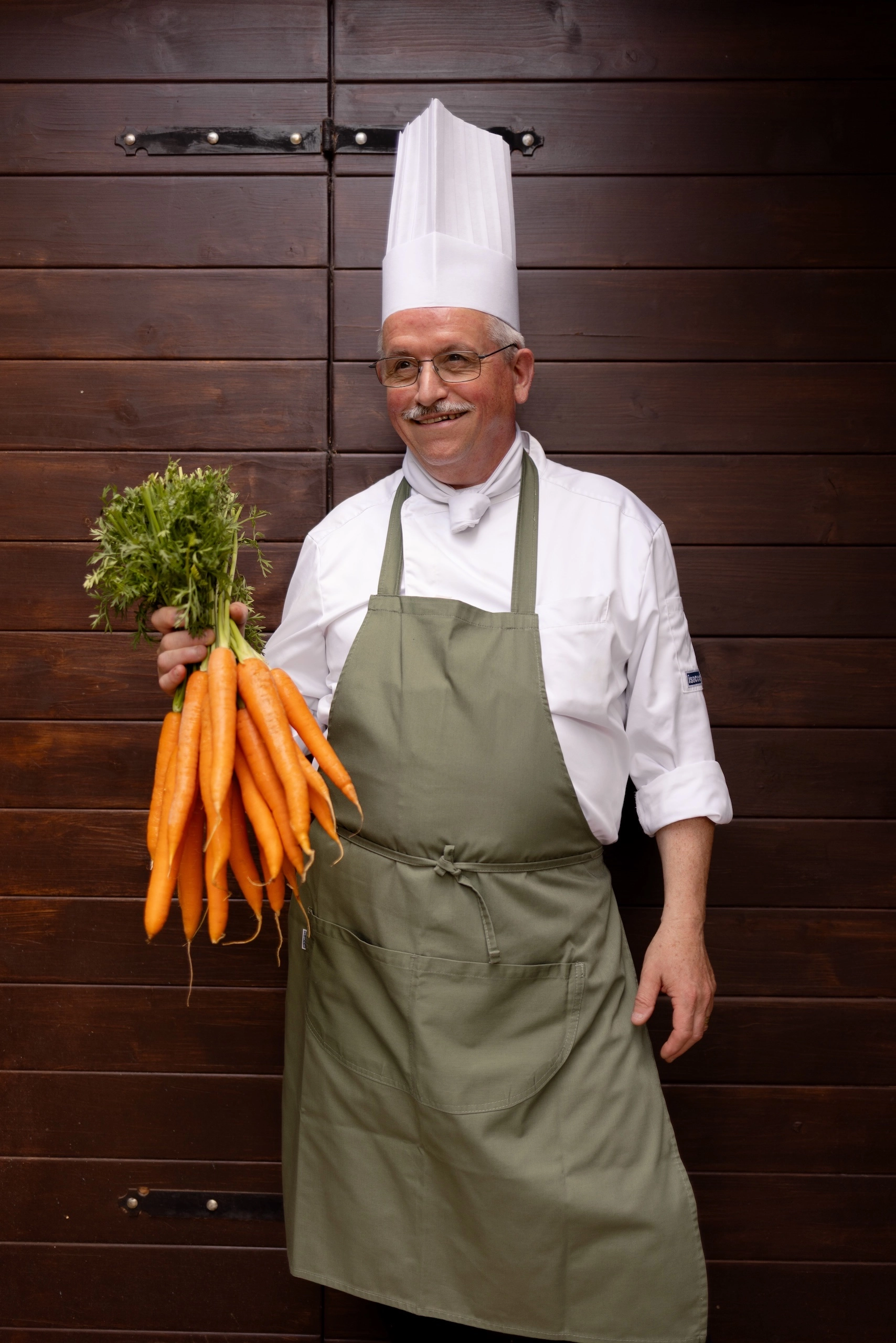 Chef Luca di Corte Gelsi con mazzo di carote fresche in cucina