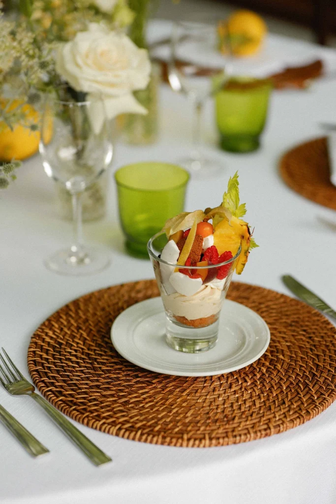 Dessert in bicchiere con frutta fresca, meringhe e crema chantilly