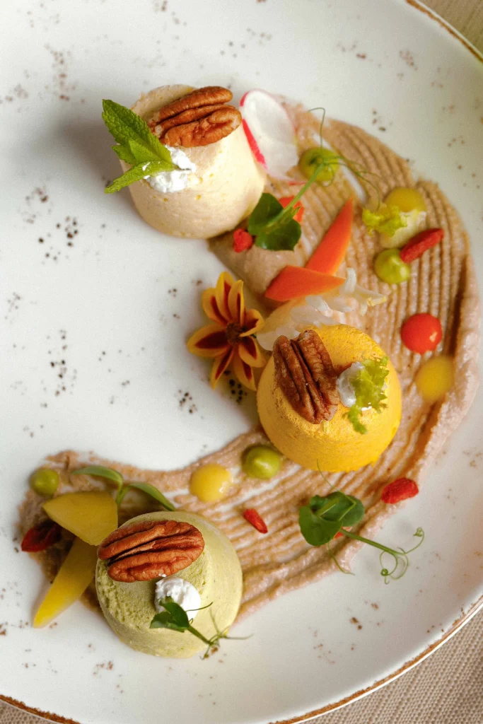 Sformatini vegetariani tricolore con mousse di verdure, noci pecan e decorazione di fiori edibili